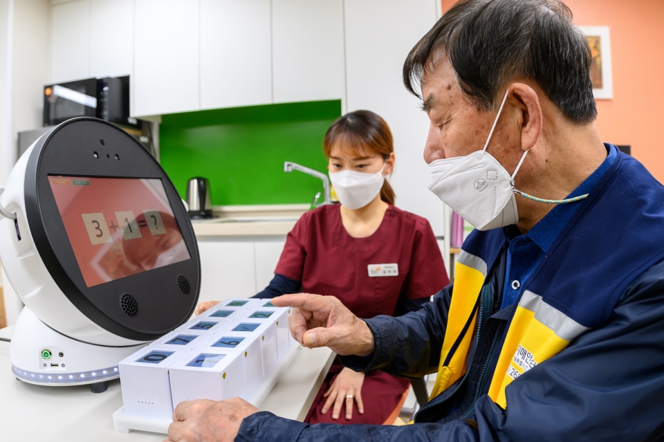 (지난 4월 서울 양천구 치매안심센터에서 한 어르신이 경증치매 가정용 인지훈련 로봇 ‘보미’ 사용법 시범을 보이고 있다. 사진=뉴시스)