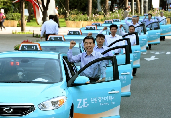 서울 중구 세종대로 서울광장에서 오는 9월까지 시범 운영되는 하늘색 전기택시를 운전하는 기사들이 파이팅을 외치고 있다.