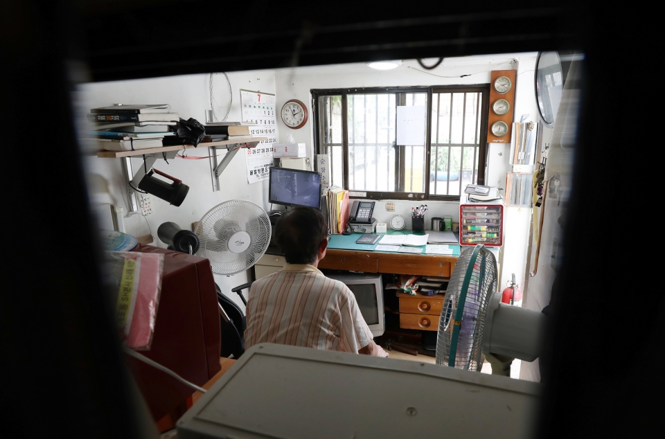 (지난 7월 14일 전국에 폭염특보가 내려진 오후 서울 시내 한 아파트 경비실에서 경비원이 선풍기를 이용해 더위를 식히고 있다. 사진=뉴시스 제공)