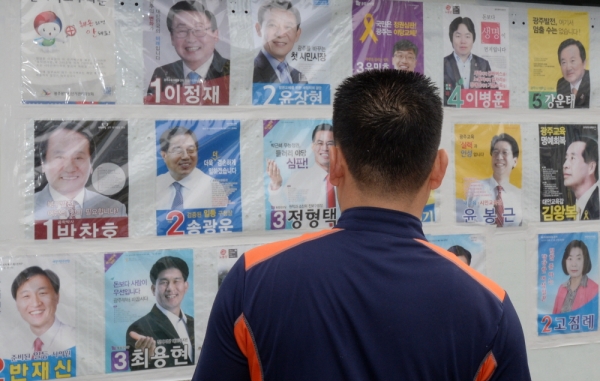 (2014년 지방선거 당시 한 유권자가 선거벽보를 보고 있다. 사진=뉴시스)