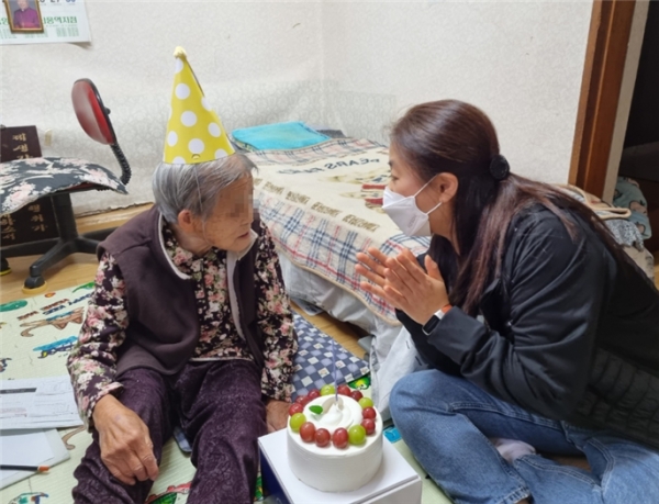 (신길6동주민센터 직원들이 홀몸 어르신을 찾아가 생일케이크를 전달하고 생일을 축하하고 있다.사진=영등포구 제공)