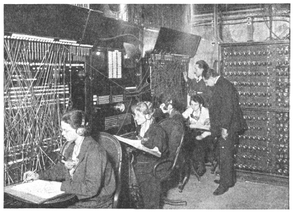 1925년 테아트로폰 컴퍼니의 유선 전송시설. 전화교환수처럼 여러 명의 직원이 기계 앞에 앉아 전송을 원하는 가입자의 유선망에 방송 선을 연결해주고 있다. 장부에 전송 시간을 기록하고 있는 것으로 보인다. 이용요금은 이용시간에 비례하여 청구되었다. 퍼블릭도메인