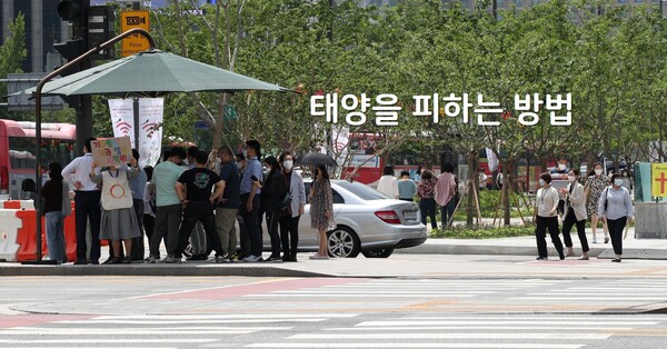 서울 광화문 사거리에 시민들이 횡단보도를 건너기 전 그늘막에서 햇볕을 피하고 있다. 사진=뉴시스 제공